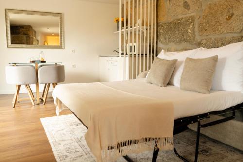a bedroom with a large bed with white sheets and pillows at Casa d'Amares in Amares