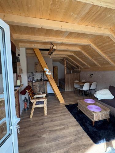 a living room with a wooden ceiling and a table at Mountains story in Bistrica Lipovska