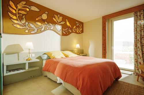 a bedroom with a large bed and a window at Les Jardins de Colmar in Herrlisheim-près-Colmar