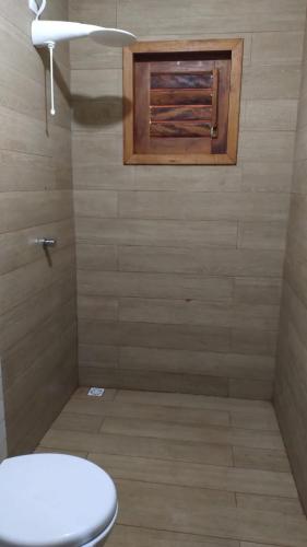 a bathroom with a toilet and a window at Recanto da Julie in Mulungu