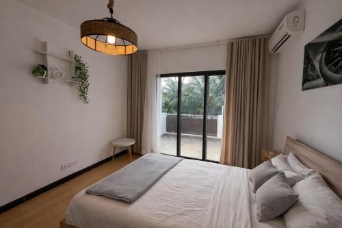 a bedroom with a bed and a large window at Chalet des Roses in Grand-Baie