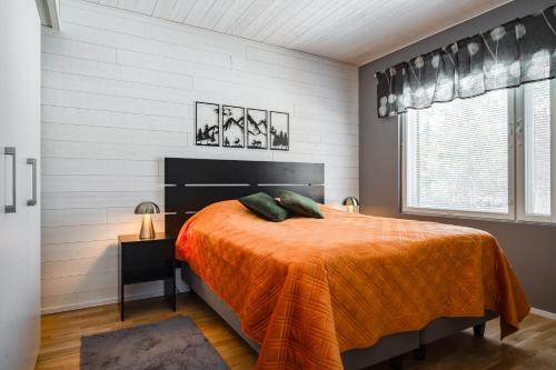 a bedroom with a bed with an orange blanket at Rukan Houkutus in Ruka