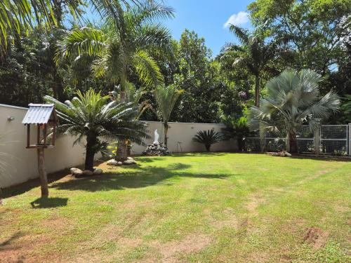 a yard with palm trees and a fence at Pousada da Aline in Sete Barras