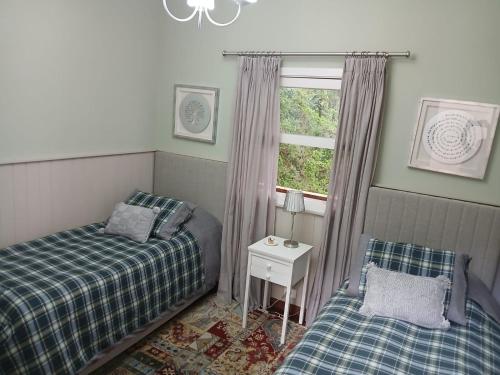 a bedroom with two beds and a window at Refúgio da Serra in Campos do Jordão
