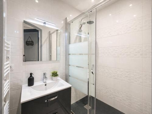a bathroom with a sink and a glass shower at T2 cosy & calme - Gare à 1 min accès direct Paris & CDG in Aulnay-sous-Bois