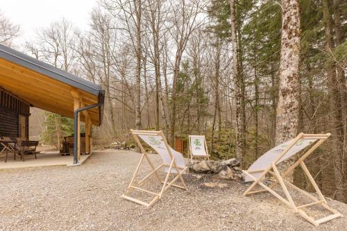 two folding chairs sitting in front of a cabin at Srčkova Koča in Kočevje