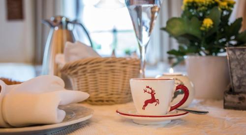 a table with a cup and a plate on a table at Hotel Mutz Garni in Inning am Ammersee
