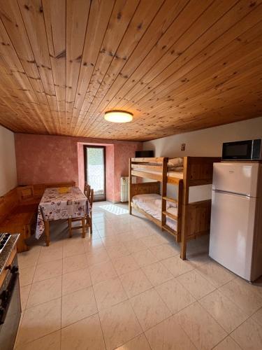 a room with two bunk beds and a table and a refrigerator at Casa parrocchiale La Salle in La Salle