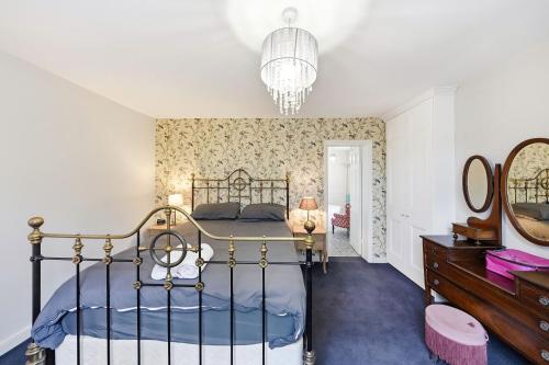 a bedroom with a bed and a dresser and a mirror at Lee's Historic Mansion in Cheshunt