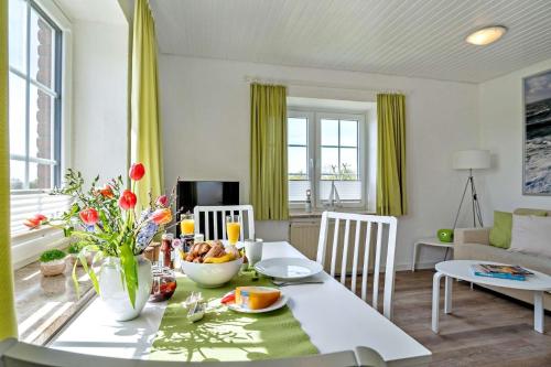 a living room with a table with a bowl of fruit at Knusthof Lafrenz - Küstenblick in Fehmarn