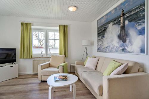a living room with a couch and a tv at Knusthof Lafrenz - Küstenblick in Fehmarn