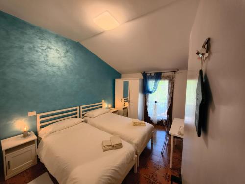 a bedroom with two beds and a blue wall at B&B Nonna Assunta in Collegiove