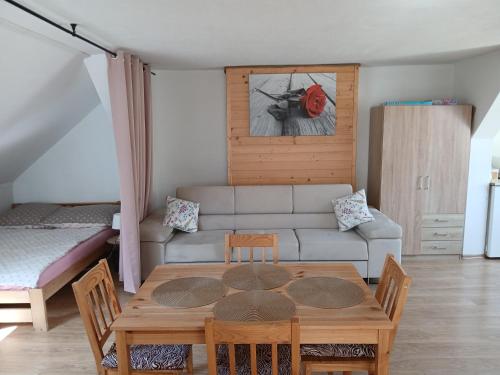 a living room with a table and a couch at Agroturystyka pod kasztanem in Lutowiska