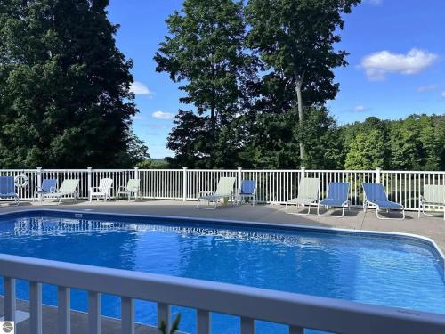 a swimming pool with chairs and a fence at Bird's Eye View at Hawk's Eye in Bellaire