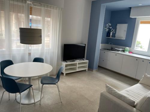 a living room with a white table and a tv at Hotel Miramare in Savona