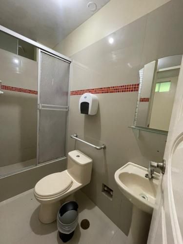 a bathroom with a toilet and a sink at Hotel Inca Perú in Piura