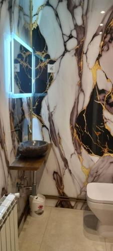 a bathroom with a marble wall with a sink at Mabel House Sierra de Gredos in Mijares