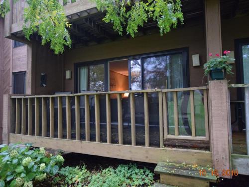 a house with a wooden railing on a porch at No Worries at Summit Village! in Bellaire
