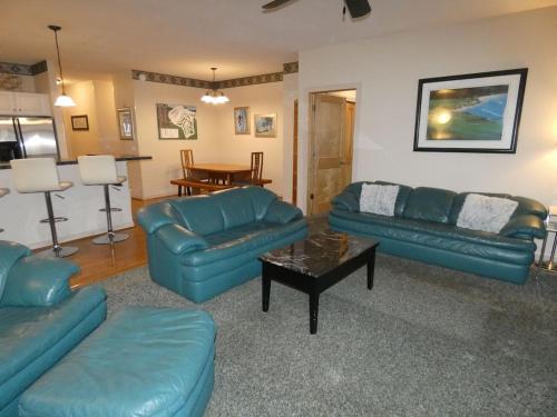 a living room with blue couches and a table at Skier's Slopeside Haven in Bellaire
