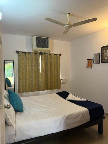 a bedroom with a bed with a ceiling fan at Apartmentbyzaara in Colva