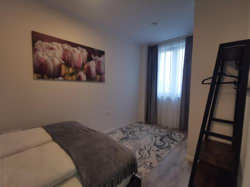 a bedroom with a bed and a painting on the wall at River Apartman 2 in Odorheiu Secuiesc