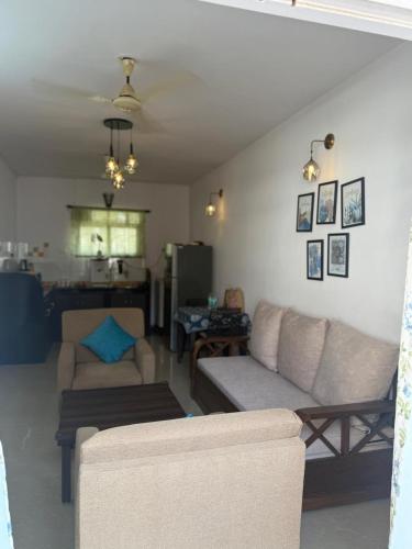 a living room with two couches and a table at Apartmentbyzaara in Colva
