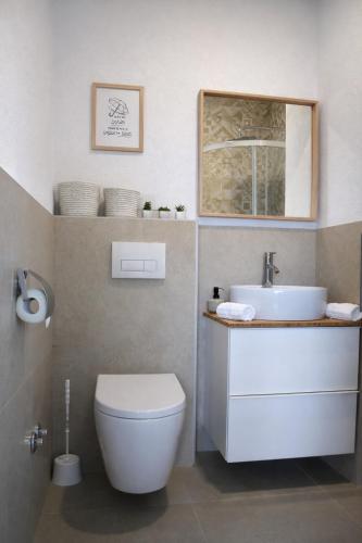 a bathroom with a white toilet and a sink at GUESTHOUSE Kastel Novi in Kaštela