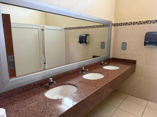 a bathroom with three sinks and a large mirror at Mega Suite en Hotel Cosmos in Tamasopo