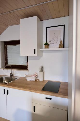a kitchen with white cabinets and a sink at Apartments Hana Bled in Bled