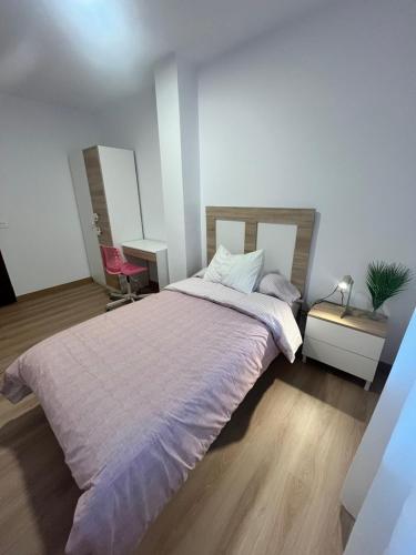 a bedroom with a large bed and a desk with a lamp at O Repouso in Lalín