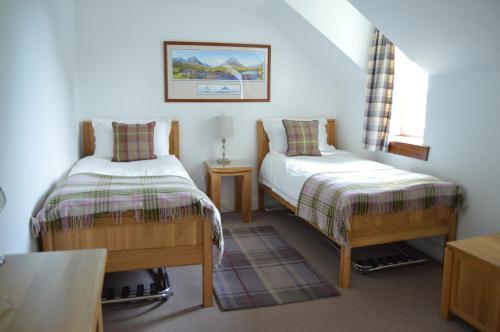 a bedroom with two beds and a window at Ness View Apartment in Inverness