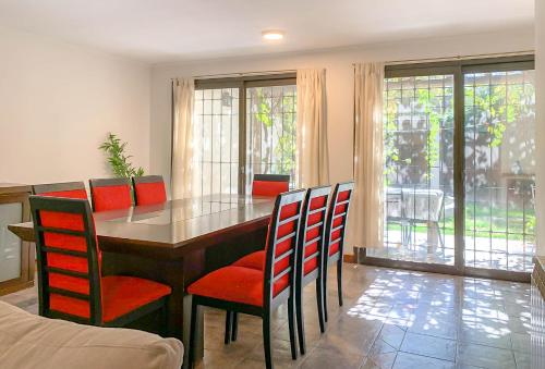 a dining room with a table and red chairs at Casa Avellaneda I 12 pax - A 6 cuadras Arístides in Mendoza