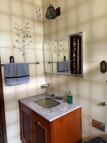 a bathroom with a sink and a mirror at NóIS DE CASA HOSTEL & SUÍTES in Belo Horizonte