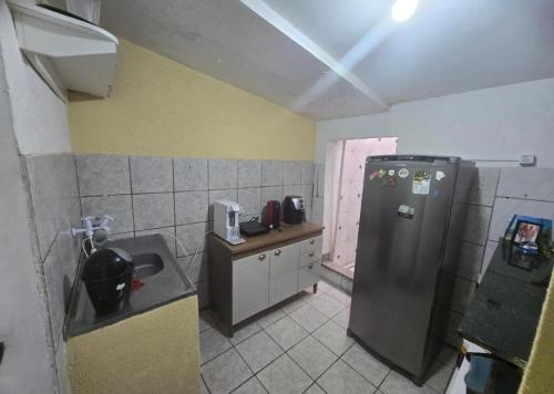 a small kitchen with a refrigerator and a sink at Quarto solteiro custo-benefício in São Luís