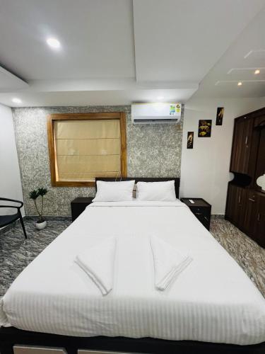 a bedroom with a large white bed in it at Elowen Villa in Mananthavady