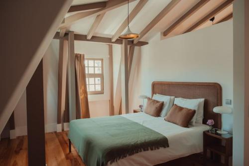 a bedroom with a large bed with a green blanket at Collares Sintra Petit Palais in Sintra