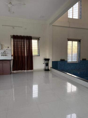 a living room with a white floor and windows at Nahta's Farm in Indore