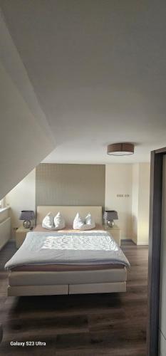 a bedroom with a bed with white sheets and pillows at Ferienhaus-Windflüchter Hirtenweg 3B in Zingst