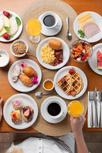 a table with plates of breakfast food on it at Palace Praia Hotel in Florianópolis