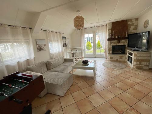 a living room with a couch and a table at Freistehendes Ferienhaus am See Nähe Roermond in Heel