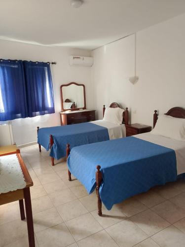 a hotel room with two beds and a mirror at Residencial Monte Sintinha in Espargos