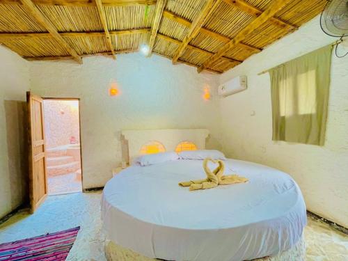 a bedroom with a bed with a ribbon on it at Adrartaziry in Siwa
