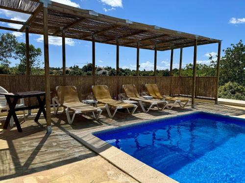 a patio with a pool and chairs and a pavilion at Algarve booking Casa Alfarrobeira Benagil Caves private parking airco heated private pool - AL in Carvoeiro