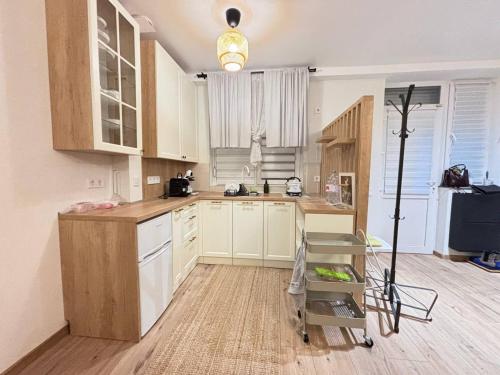 a kitchen with white cabinets and a wooden floor at Dimo Cozy Apartments Chisinau Moldova Centre Airport in Chişinău