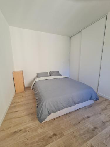 a bedroom with a bed and a wooden floor at Keo Home in Arbent