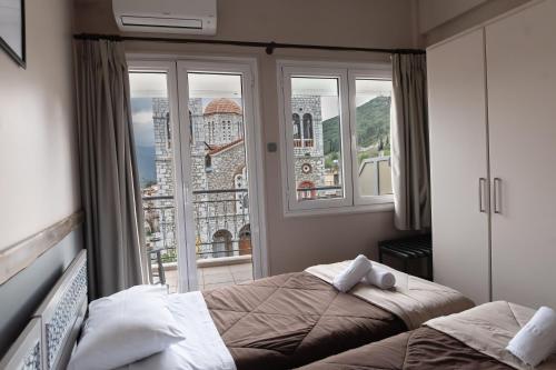 a bedroom with a bed and a large window at Hotel Koutriaris in Distomo