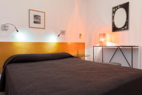 a bedroom with a bed and a mirror on the wall at Hotel Cala di l'Oru in LʼÎle-Rousse