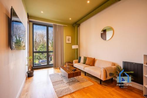 a living room with a couch and a table at Spacious Manchester City Condo - Parking - Next To AO Arena - Local Attraction & Transport Links in Manchester