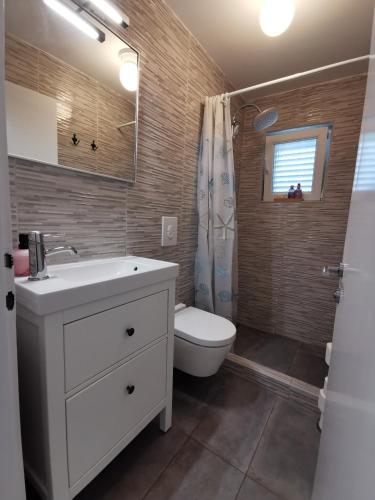 a bathroom with a white sink and a toilet at Apartman Magdalena in Cres
