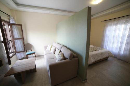 a bedroom with a bed and a couch and a chair at Asamina Boutique Hotel in Soûr
